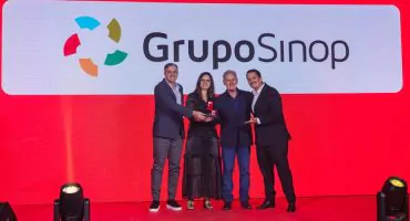 Equipe do Grupo Sinop recebendo o selo Great Place to Work Centro-Oeste no palco